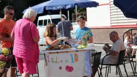 Milla med sin bror Marius, 12 år, vid den allra första bullförsäljningen på i Norrtälje den 2 augusti 2011. Marius har funnits vid Millas sida hela tiden och hjälpt henne.