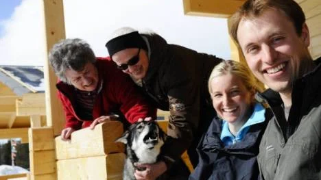Sabrina Patzelt och Tobias Stowasser, till höger, lever nära sina gäster. Deras jämthund Nookie uppvaktas av de tyska sommarcamparna  Gisela Burgdorf och Ursula Bretzl på farstun till de nybyggda storstugorna.