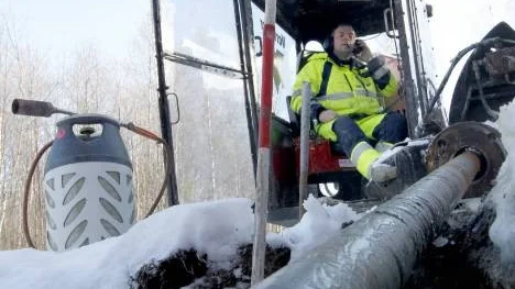 Nisse Westberg matar på specialstålborren med nya längder för att köra upp ett flera hundra meter långt hål i backen, ämnat en ny avloppsledning.