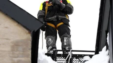 INGVAR MED LIVLINA. Snöskottare på tak måste ha en ordentlig säkerhetslina. Och det har naturligtvis Ingvar Forss, som här tagit en paus i snöskottandet fyra våningar upp på taket till ett hyreshus i Luleå.