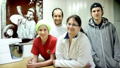BAGARFAMILJEN. Pierre Dellaert, Vera Wollaert och barnen Jonas och Jensen lämnade tättbefolkade Belgien, köpte hus i Sörbyn, byggde om garaget och återupptog bageriverksamheten. Bilden i bakgrunden visar hur bagarna i Belgien en gång i tiden annonserade att brödet var klart.