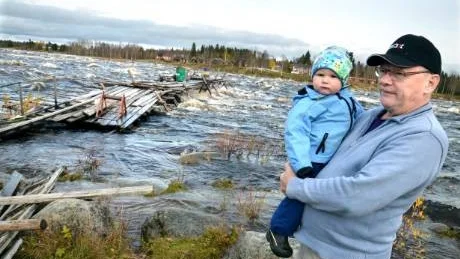 VÅGAR INTE. "Vattnet är för högt för att våga ta in patan", säger Svante Spoalnder, med  barnbarnet Viktor i famnen.