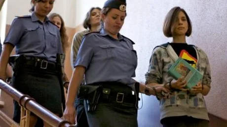 Mot Rättegångssalen. Jekaterina Samutsevitj, Maria Alechina och Nadezjda Tolokonnikova leds till rättegångssalen. Nadezhda Tolokonnikova håller boken Women´s Liberation Movement in Russia. Feminism, Nihilism and Bolshevism i handen.