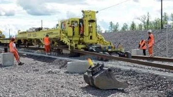 PÅ RÄLS. Denna maskin är sällsynt i Sverige, men arbetar just nu med att lägga ut räls för Trafikverkets nya järnväg i Kiruna. Arbetet genomförs på grund av gruvbrytningen i samhället och den nya järnvägssträckningen bekostas av LKAB.