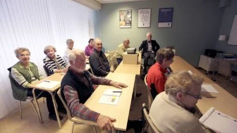 En grupp lärdomstörstande elever tillsammans med kostymklädda läraren Dick Cederquist