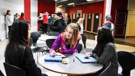 LÄXOR. Frida Johansson (i lila) går igenom glosorna med Mahabat Jamshidi och Denise Kemphälä.  Alla tre trivs bra på Herstöskolan. "Det är mycket sport och folk man känner" säger Frida.