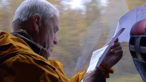 Historielektion i buss. Kurt Carlman studerar en gammal karta över Silvervägsområdet.