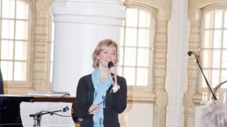 Körledare Anette Jernelöf läste dikter, spelade piano och sjöng ackompanjerad till körtjejernas stämsång.