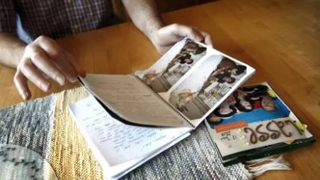 Lars Lundberg tittar igenom den dagbok med bilder som personalen gjorde i ordning åt honom när han låg nedsövd på IVA på Umeå Universitetssjukhus. Intill ligger också en liten bok med text och bilder som anhöriga knåpade ihop.