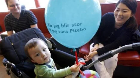 Unge Kevin Jonsson, knappt ett år, håller krampaktigt i ballongen med budskapet "När jag blir stor vill jag vara Pitebo". Äkta paret Jonsson, Markus, 30, och Carrie, 29, är nyinflyttade från Skellefteå. "Piteå är en trevlig plats att bo på", förkunnade Markus, anställd på Swedbank, och Carrie, mammaledig utbildad arbetssökande kemiingenjör.