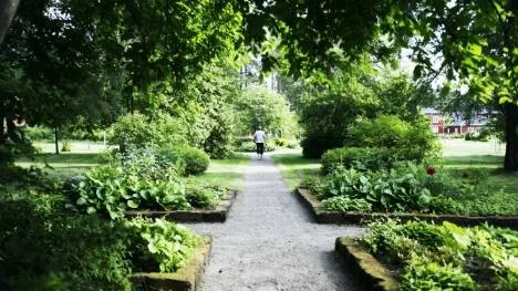 På grusade gångbanor kan besökarna strosa och njuta av prunkande blomrabatter och mäktiga träd.