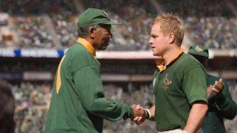 Matt Damon (höger) är mannen som kan spela alla sorters roller men som, inser man nu, ser exakt ut som en sydafrikansk rugbykapten. Kanske är det paradoxalt nog därför man hela tiden ser inte en rugbykapten på duken utan Matt Damon?