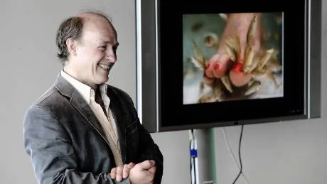 RISK YOUR SKIN. Biennalens curator Jan-Erik Lundström presenterar Tilman Küntzels verk där besökare kan låta små fiskar i ett akvarium äta upp gammalt skinn från sina fötter.