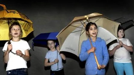 REGNSÅNG. Till ett "nummer" i föreställningen hade barnen plockat fram paraplyerna och sången de sjöng var förstås Singin´ in the rain, Gene Kellys paradnummer från filmen med samma namn.Foto: HÅKAN GIDLÖW
