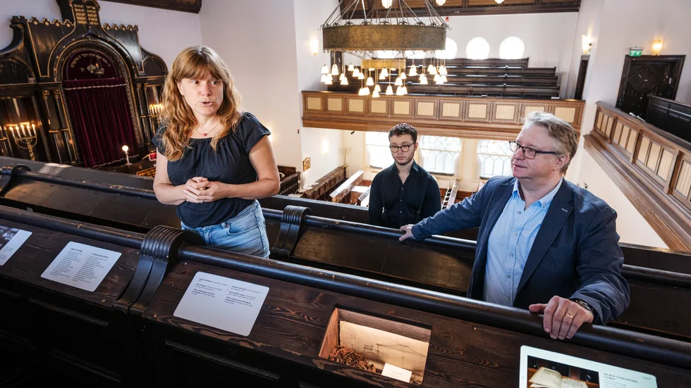 Judiska församlingen har skapat ett judiskt kunskapscenter i synagogan i Malmö. Utställningsproducenten Sofie Bergkvist och verksamhetsledaren Fredrik Sieradzki visar här upp en tidslinje – som byggts in i befintlig inredning – om judarnas historia i staden.