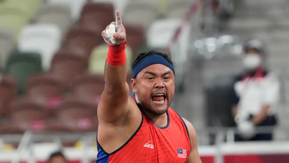 Muhammad Ziyad Zolkefli jublar över en lång stöt i kultävlingen i Paralympics, innan han diskades för sen ankomst.