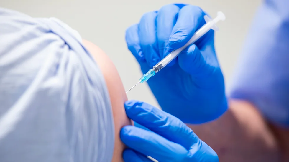 En vaccinatör ger en man en dos vaccin. Arkivbild.