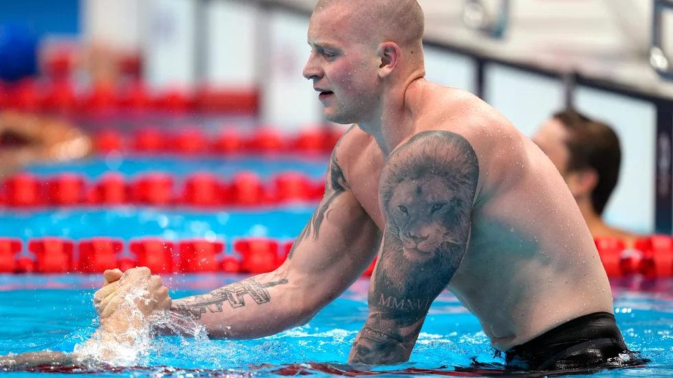 Adam Peaty, Storbritannien, firar sitt OS-guld, men säger att det är svårt att ta fram "det lilla extra" när publiken saknas.