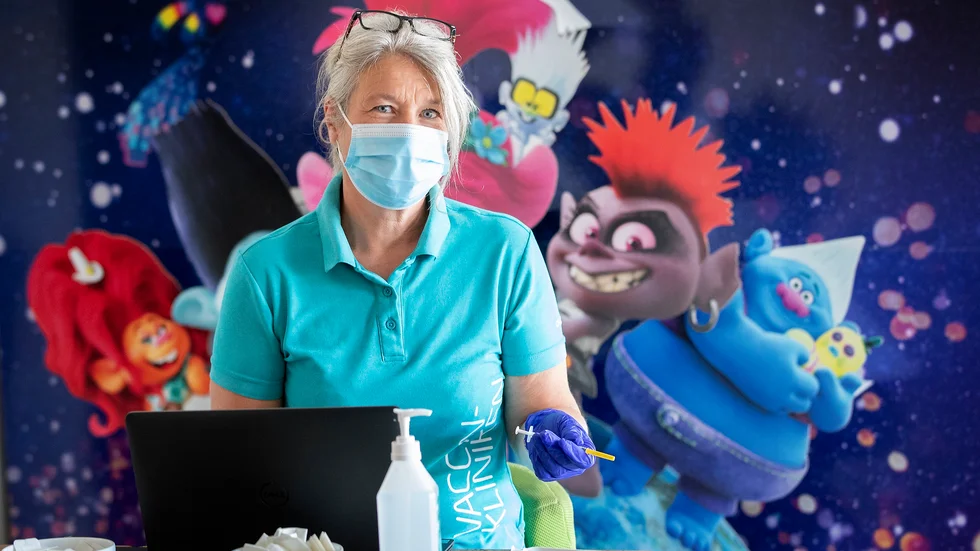 Vaccinkliniken i Nyköping ligger i samma byggnad som bion, och har lånat bioreklamen för att bygga skärmar mellan vaccinationsbåsen. Cecilia Rylander är en av dem som vaccinerat.