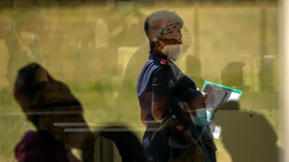 En vårdarbetare i Johannesburg väntar på att få vaccin i en bild från i mars.