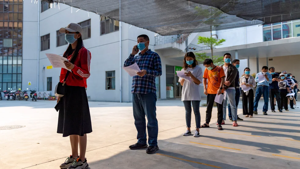Invånare i den kinesiska staden Ruili, som gränsar till Myanmar, köar för att ta covidvaccin.