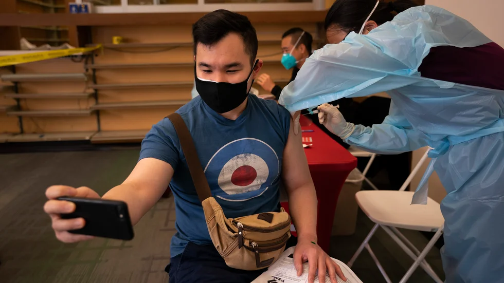 31-årige Freeson Wong tar en selfie medan han får en dos Modernavaccin i Los Angeles i april.