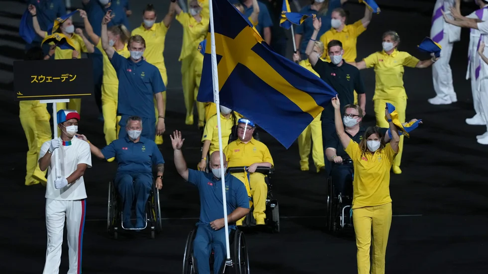 Stefan Olsson och Helene Ripa med den svenska fanan på invigningen.
