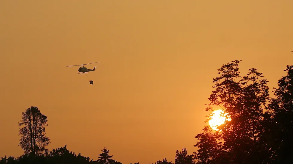 Helikopter vattenbombar i Vrinneviskogen.
