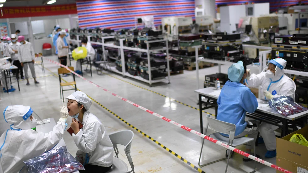 Arbetare testas för covid-19 vid Foxconns fabrik i Wuhan i veckan. Elva miljoner invånare i staden har provtagits sedan i tisdags.