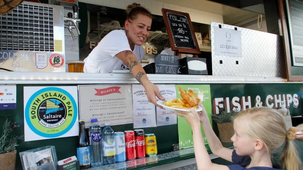Caroline Karlsson, manager på Milners fish & chips, serverar en rejäl portion till 7-åriga Svea Maschmann.