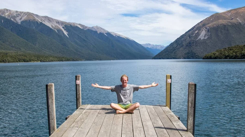 Patrik njuter på bryggan I Nelson Lakes nationalpark där sjöarna omringas av höga berg.
