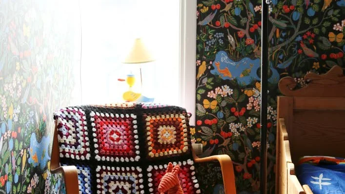 Nostalgi. Fåtölj, filt, lampor och säng - allt är arvegods från Christellas familj. Till och med tapeten som är Paul Frank original.