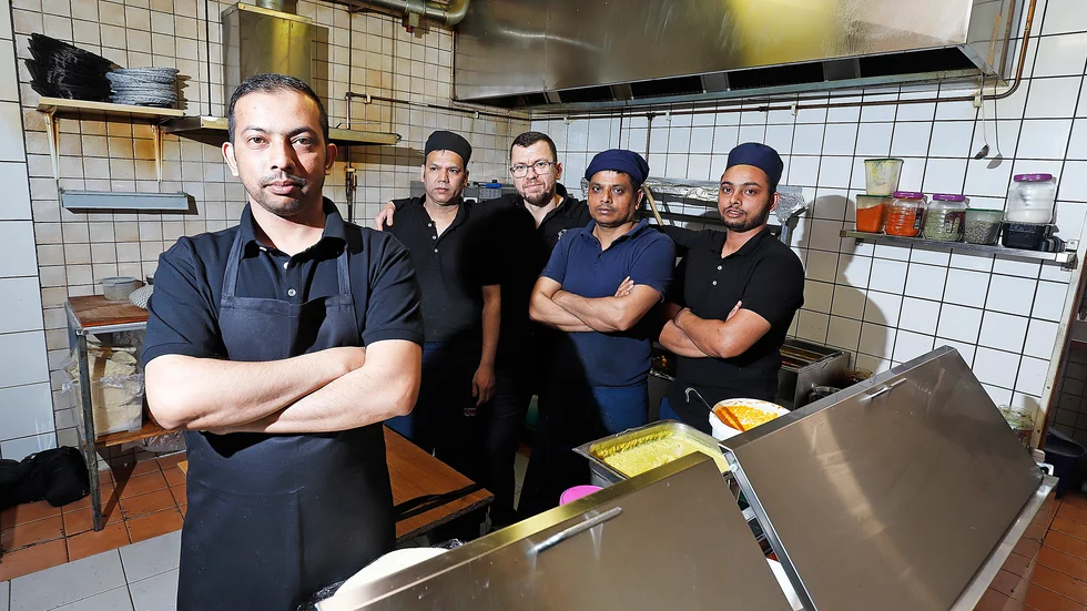 Sayed Chowdhury längst fram är ägare till restuarangen, i bakgrunden ses hans personal: Monir Sardar, Musa Nazar, Shopan Chowdry, Tanim Chowdhury.
