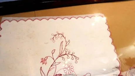 Släktbroderi. Agnes Liljegren, född Kalmén som är Evy Ernstssons kusins mormor, broderade duken i bild och hennes eller hennes mans föräldrar är porträtterade på det gamla fotot.