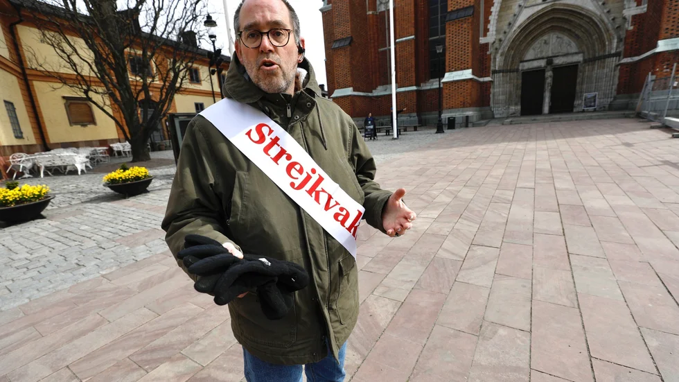 Strejkvakten Patrik Sköldberg står på fredagen utanför domkyrkan och förklarar för besökare varför det inte går att komma in.