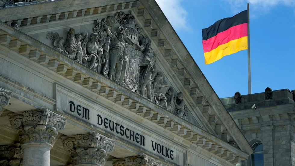 En tysk flagga vajar bakom parlamentet i Berlin. Arkivbild.
