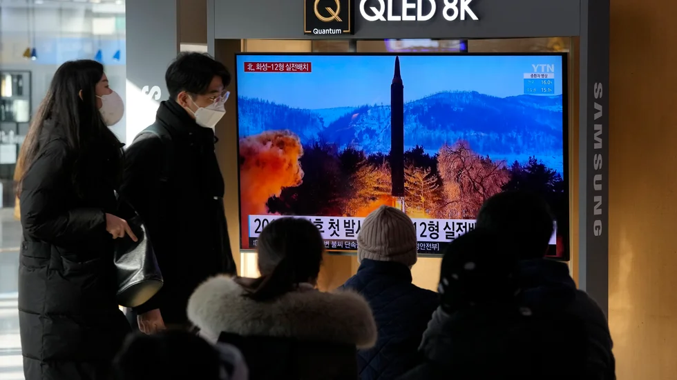 Tågpendlare i Seoul tittar på en nyhetssändning som visar det senaste nordkoreanska robottestet.