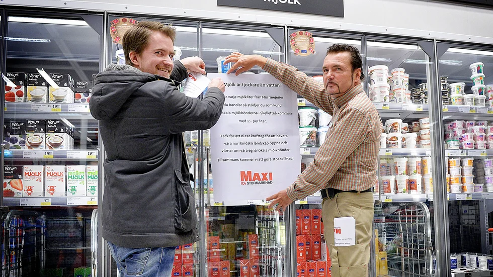 Höjer priset. ”Kunden gör en stor insats och kan genom ett aktivt val stödja lokala mjölkbönder”, säger Åker Persson som tillsammans med Markus Lindgren sätter upp informationslappar till kunderna vid mjölkdisken.
