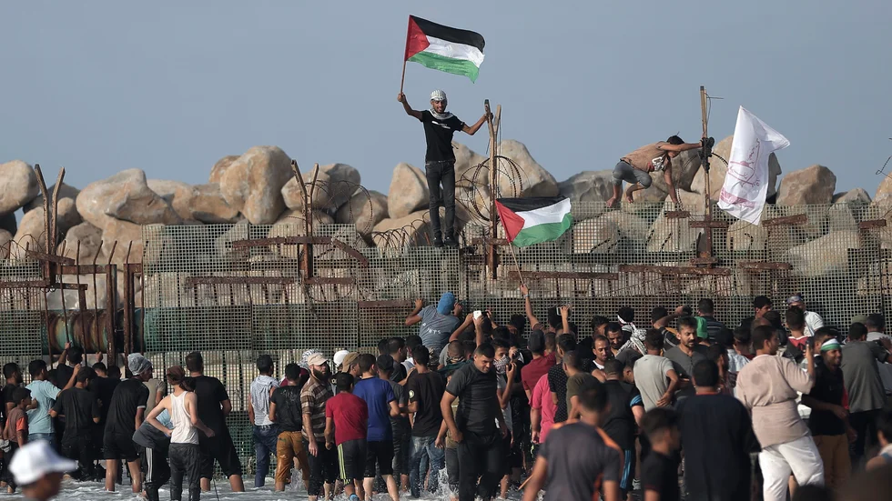 Palestinian protesters gather at the border fence with Israel during a protest near Beit Lahiya, northern Gaza Strip, Monday, Oct. 8, 2018.(AP Photo/Khalil Hamra)