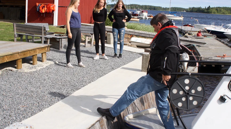 Ronny Lindström, Nordisk Sjötaxi, stiger iland i Örviken. I bakgrunden sommarentreprenörerna Tove Larsson, Ebba Elenius och Niva Sjöstedt.