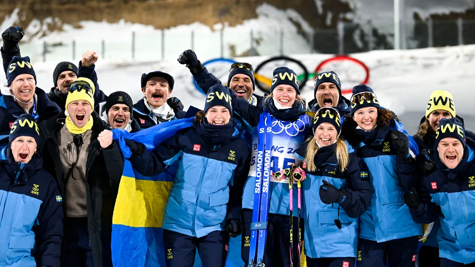 Systrarna Öberg och resten av landslaget jublar efter Elvira Öbergs silver i skidskyttesprinten. Hanna (till vänster) och Elvira i mitten av bilden.