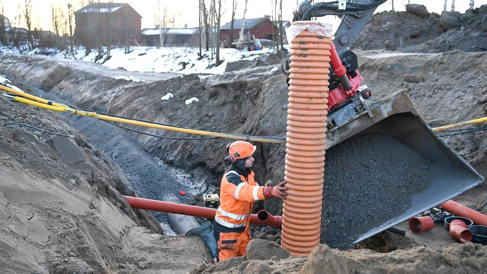 Där ledningen korsar en gata ska rör för regn- och tövatten dras. Här håller Daniel Fernberg ett sådant medan vattenledningen skymtar i bakgrunden. Foto: Jeanette Lövgren.