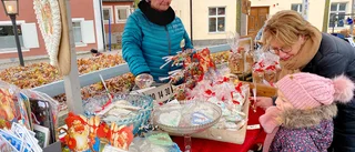 Tätt med tomtar, kransar och besökare på julmarknaden