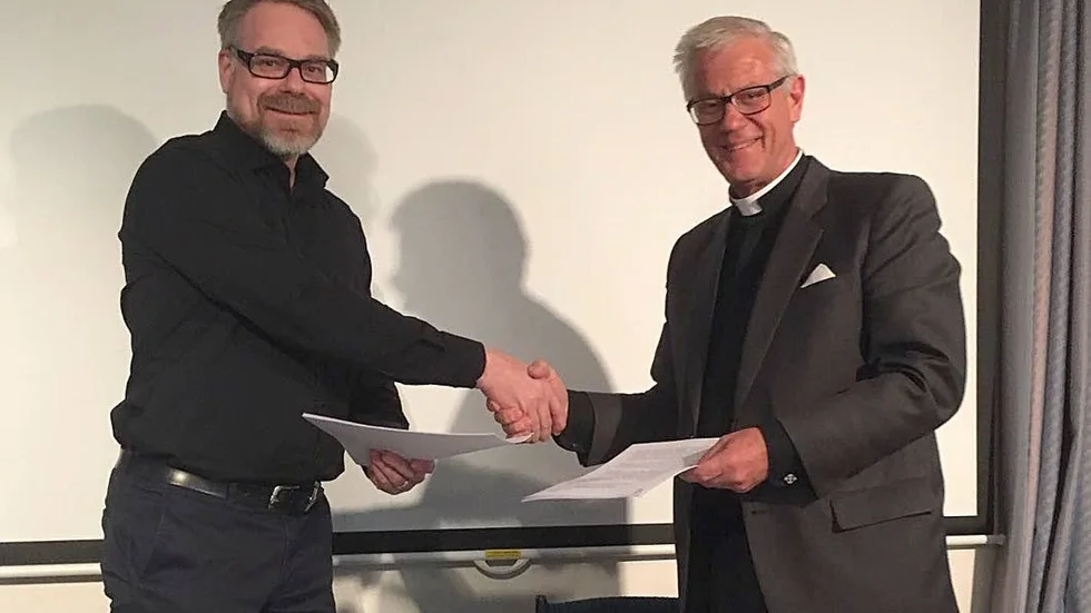 Klas Dahlström, ordföranden i församlingen Vineyard och Krister Wos Andersson, ordförande i Immanuelskyrkan, Norrköping med den signerade överenskommelsen.