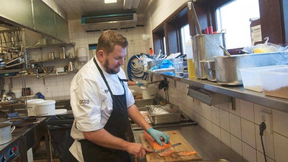 Johan Brunnström skär upp små laxbitar.