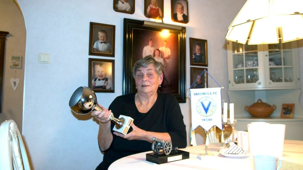Årets Värmboling kan hon med stolthet kalla sig, Suoma Rautiainen. Bakom hennes på väggen sitter fotografier på de tre sönerna, Jukka, Timo och Jari, samt deras barn. Oavsett idrott försöker hon att följa dem så gott det går.