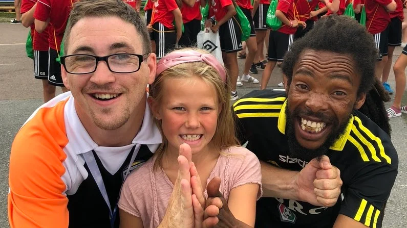 Pressansvarige Alan Booth, maskoten Clara Thell och tränaren Rasta Xulu.