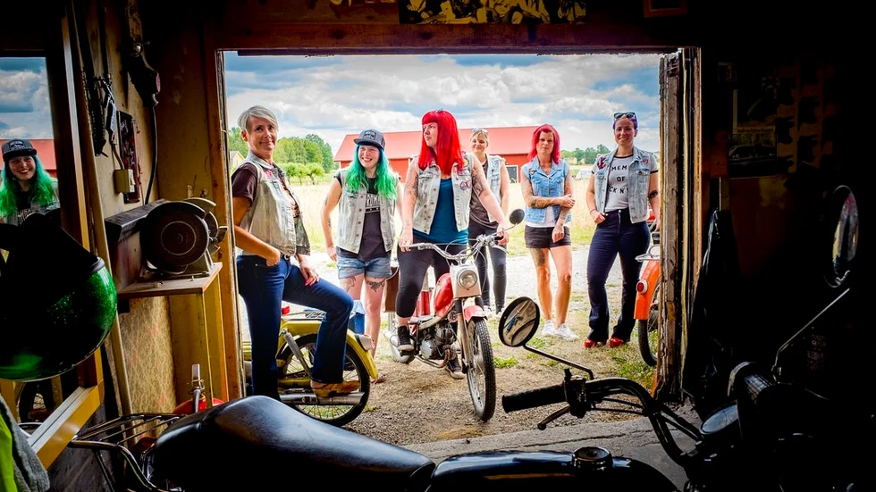 Gänget står samlat framför garaget i sina jeansvästar. De bemästrar inte helt sina mopenmeckarkunskaper än men lär sig tids nog.