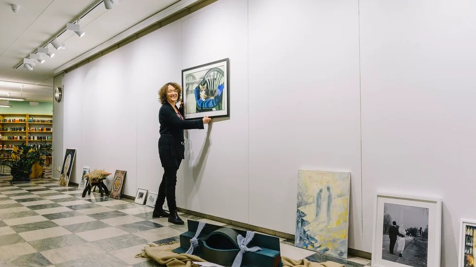 Eva Josephson är utställningsansvarig på Culturum. Här hänger hon Tomas Rings torrpastell "Favoritplatsen".