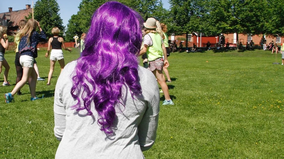 Färgstarka Karin Stenmark bevittnar en match i bollspelet quidditch på Midsommarängen.